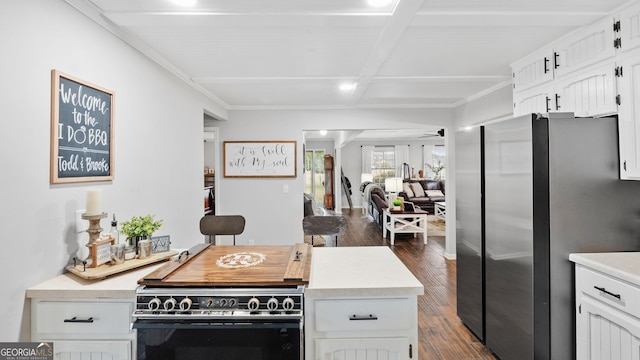 kitchen with dark wood-style flooring, light countertops, black electric range oven, freestanding refrigerator, and white cabinetry