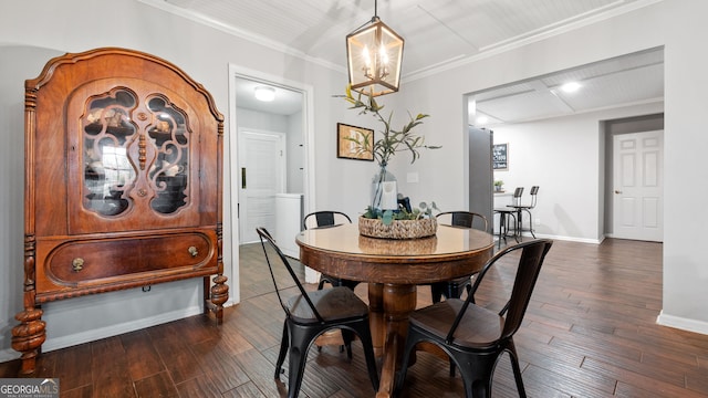 dining space featuring dark wood-style floors, a chandelier, crown molding, and baseboards