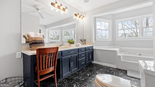 bathroom featuring a ceiling fan, marble finish floor, a garden tub, and vanity