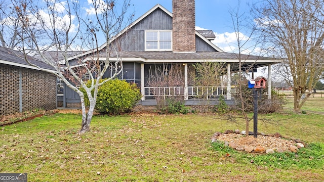 back of house featuring a sunroom, a chimney, and a yard