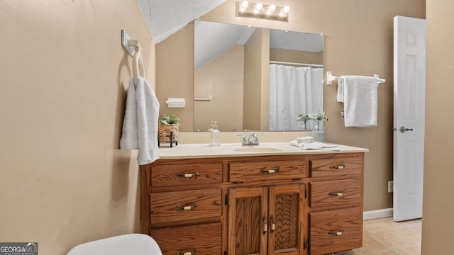 bathroom with toilet, vanity, and baseboards