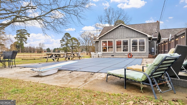 view of swimming pool with a diving board, a patio, and a fenced in pool