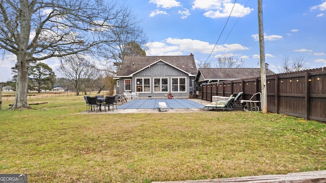 rear view of property with a yard, roof with shingles, fence, and a patio