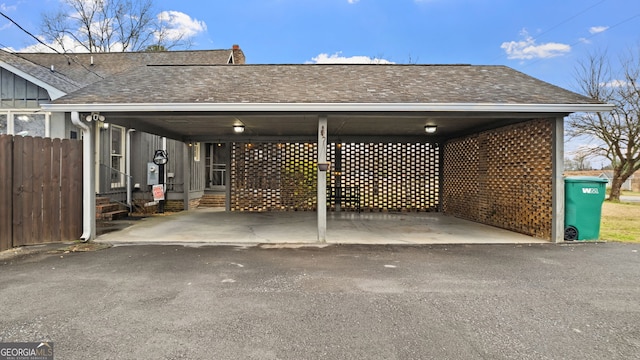 view of parking featuring driveway, fence, an attached carport, and entry steps