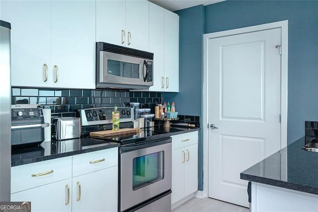 361 17th St Unit 2122, Atlanta, GA 30363 - kitchen with appliances with stainless steel finishes, dark stone counters, and white cabinetry