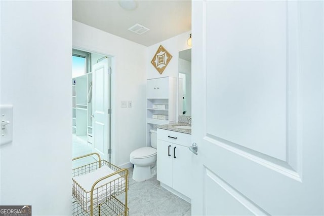 bathroom with visible vents, vanity, toilet, and tile patterned floors