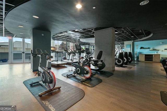 gym featuring floor to ceiling windows, plenty of natural light, and wood finished floors