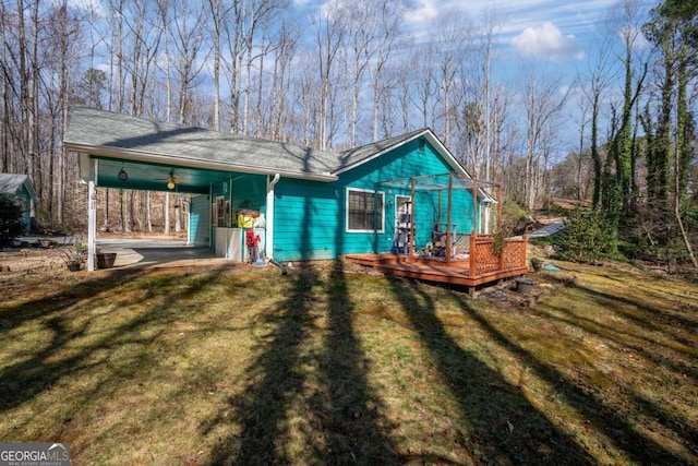 exterior space featuring driveway, an attached carport, and a front yard