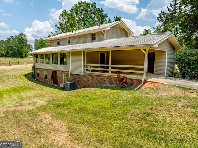 view of front of home with metal roof, brick siding, and driveway