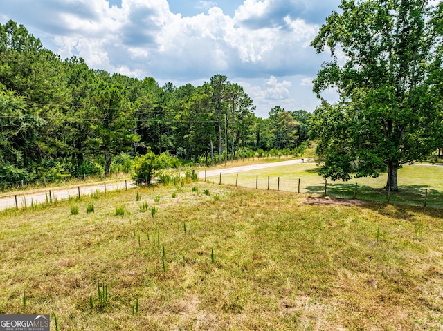 view of yard with fence and a wooded view