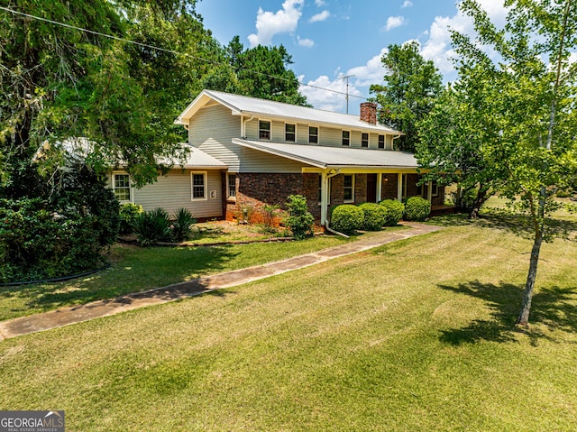 view of front of house with brick siding, a chimney, and a front lawn