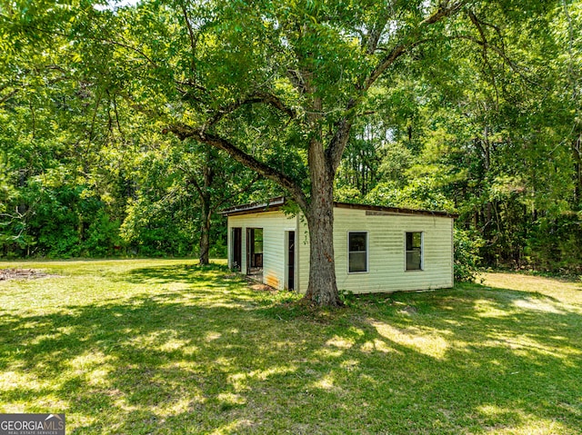 view of yard featuring a forest view and an outdoor structure