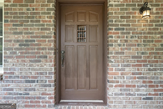 entrance to property featuring brick siding