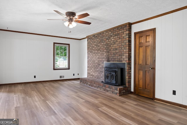 unfurnished living room featuring visible vents, ornamental molding, a textured ceiling, wood finished floors, and baseboards