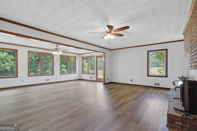 unfurnished living room with a textured ceiling, visible vents, and wood finished floors