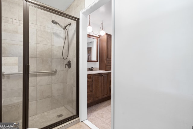 bathroom with tile patterned flooring, a shower stall, and vanity