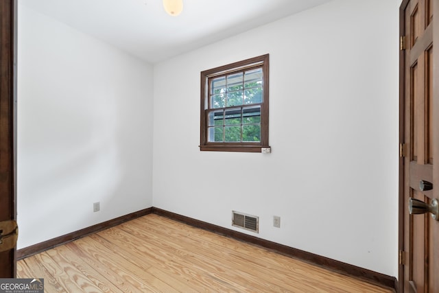 empty room featuring baseboards, visible vents, and light wood-style floors