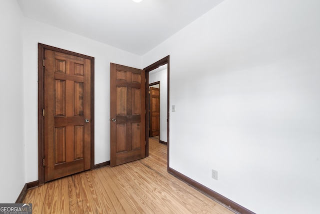 unfurnished bedroom featuring light wood finished floors and baseboards