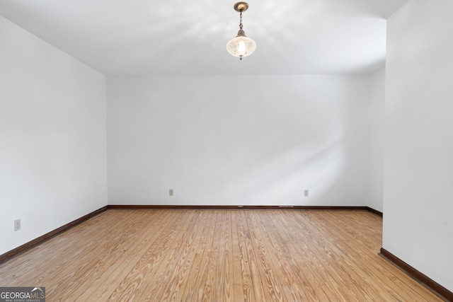 empty room with baseboards and wood finished floors