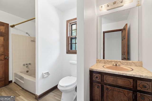 full bath with shower / washtub combination, toilet, vanity, wood finished floors, and baseboards