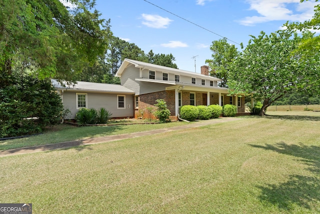 back of property featuring brick siding, a lawn, and a chimney