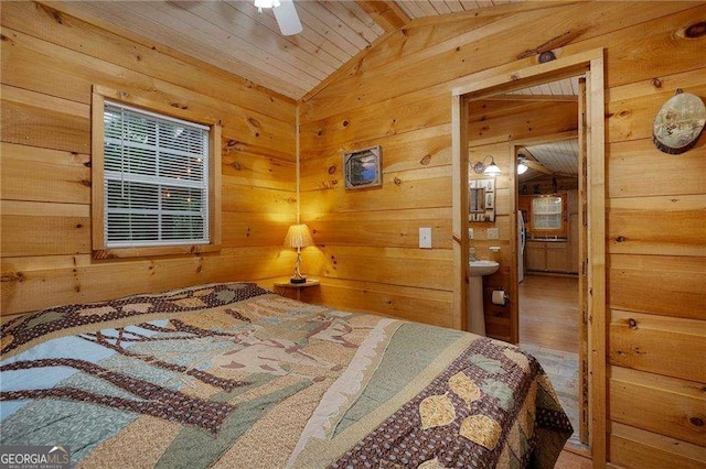 bedroom with wood ceiling, wood walls, ensuite bath, and vaulted ceiling