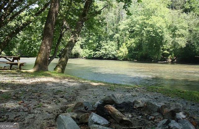 view of yard featuring a water view and a wooded view