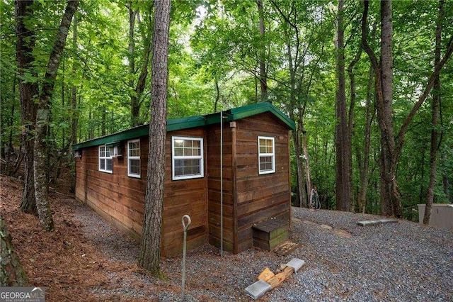 view of outbuilding featuring a forest view and an outdoor structure