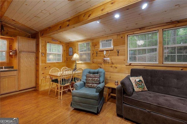 living area with vaulted ceiling with beams, wooden ceiling, wooden walls, light wood-type flooring, and a wall mounted air conditioner