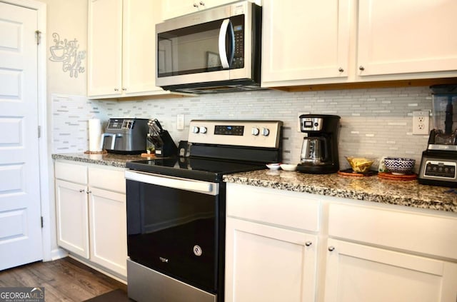 kitchen featuring appliances with stainless steel finishes, stone counters, backsplash, and white cabinetry