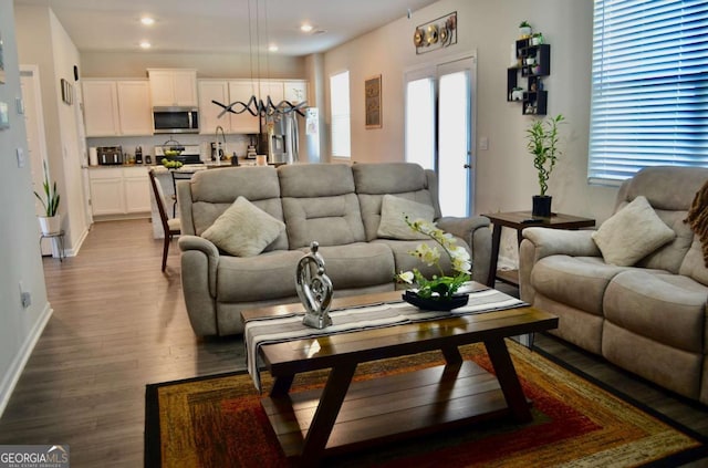 living area with baseboards, dark wood finished floors, and recessed lighting