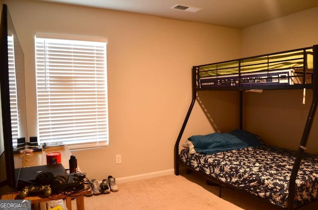 bedroom featuring carpet floors, visible vents, and baseboards