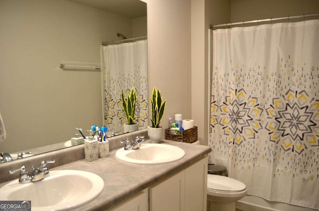 bathroom featuring double vanity, shower / bath combo with shower curtain, a sink, and toilet