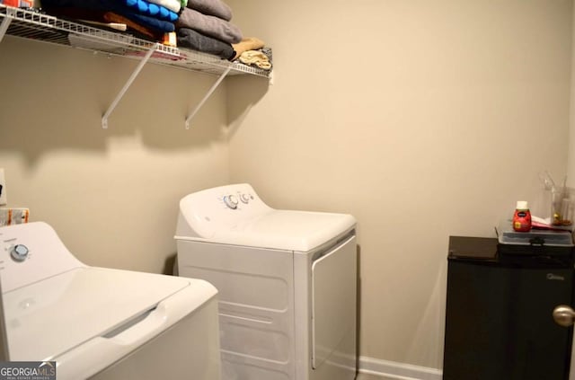 laundry area featuring laundry area, baseboards, and washing machine and clothes dryer