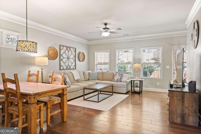 living room featuring baseboards, crown molding, a ceiling fan, and dark wood-type flooring