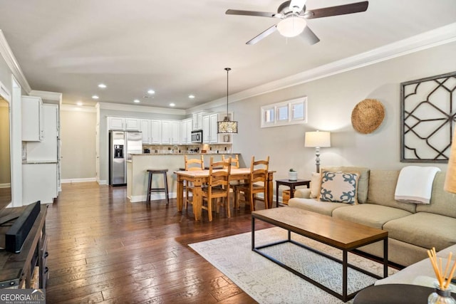 living room featuring a ceiling fan, dark wood-style flooring, crown molding, and baseboards