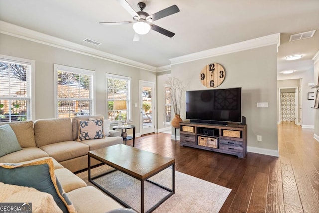 living area featuring dark wood-style floors, visible vents, plenty of natural light, and ornamental molding