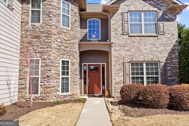 view of exterior entry with brick siding