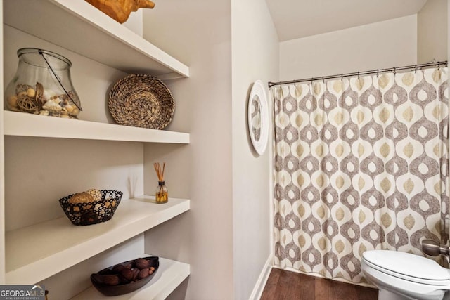 full bathroom featuring toilet, curtained shower, baseboards, and wood finished floors