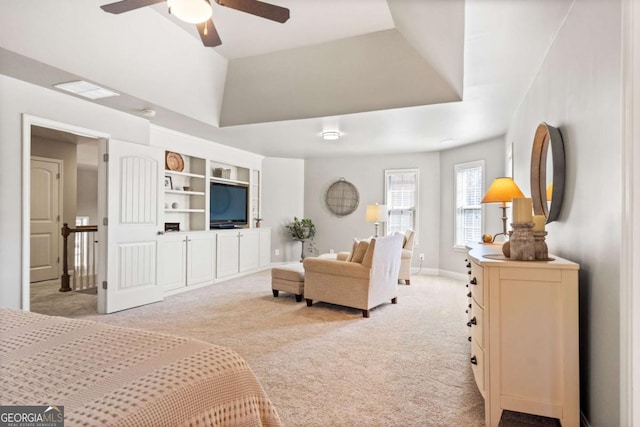 carpeted bedroom featuring a raised ceiling, a ceiling fan, and baseboards