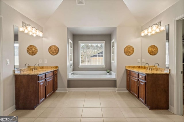 full bath featuring two vanities, vaulted ceiling, a sink, and tile patterned floors