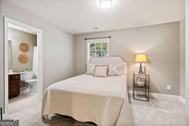 bedroom featuring baseboards, connected bathroom, visible vents, and light colored carpet