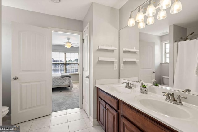 full bathroom featuring toilet, tile patterned flooring, double vanity, and a sink