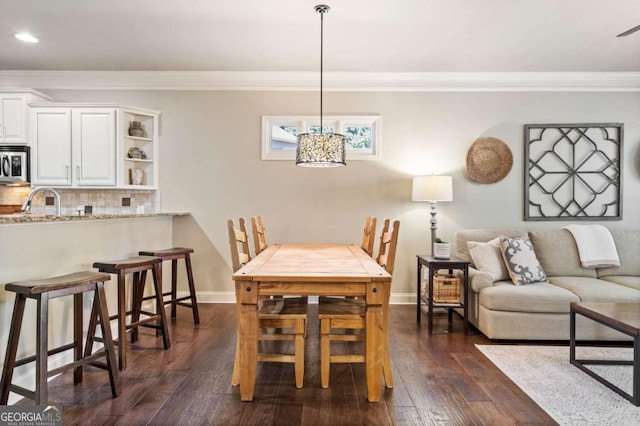 dining room with dark wood-style floors, baseboards, crown molding, and recessed lighting