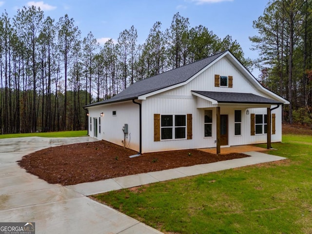 modern farmhouse style home featuring a shingled roof, a front yard, and concrete driveway