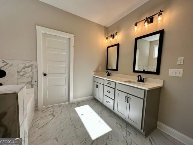 full bath with marble finish floor, washer / clothes dryer, and a sink