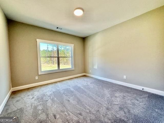 carpeted empty room with visible vents and baseboards