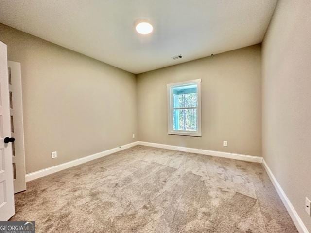 carpeted spare room with baseboards and visible vents