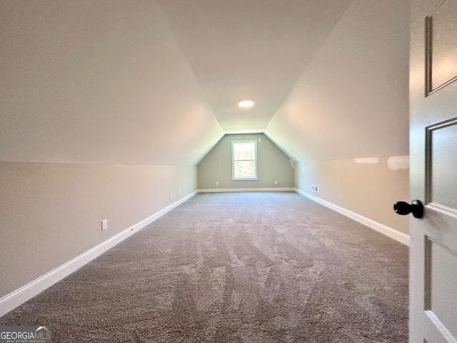 additional living space featuring lofted ceiling, baseboards, and carpet flooring