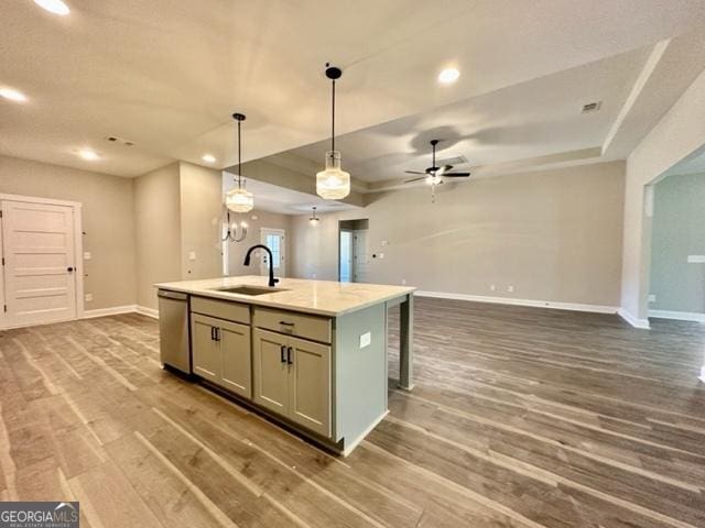 kitchen with a tray ceiling, open floor plan, a sink, and dishwasher